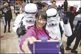  ?? AFP ?? A Japanese woman takes a selfie with ‘ Star Wars’ stormtroop­ers during the Tokyo Comic Con in Chiba yesterday.