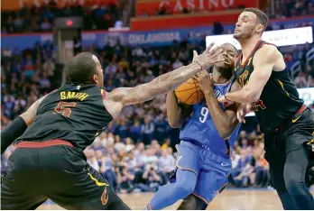  ?? AP ?? Oklahoma City Thunder forward Jerami Grant (centre) drives between Cleveland Cavaliers guard J.R. Smith (left) and forward Larry Nance Jr. during the second half of their NBA basketball game in Oklahoma City on Tuesday. Cavaliers won 120-112. —