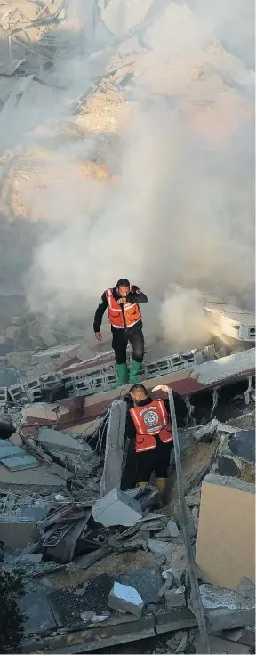  ?? AP ?? Bomberos palestinos buscan supervivie­ntes entre las ruinas en Rafah