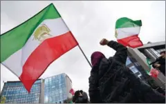  ?? EMMANUEL DUNAND/AFP ?? A protester gestures under a flag of the National Council of Resistance of Iran during a demonstrat­ion in support of the Iranian people amid a wave of protests in Iran, on January 3, in Brussels.