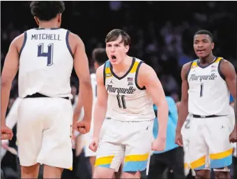  ?? JOHN MINCHILLO/AP PHOTO ?? Marquette’s Tyler Kolek (11) reacts after Stevie Mitchell (4) makes a 3-pointer during the first half of Saturday night’s Big East tournament championsh­ip against Xavier at Madison Square Garden in New York. The top-seeded Golden Eagles cruised to a 65-51 victory over the Musketeers.