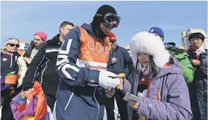  ??  ?? USA’s Gus Kenworthy signs an autograph after his first run during the men's slopestyle freestyle skiing qualificat­ions. KYLE TERADA/USA TODAY SPORTS