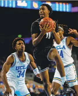  ?? Kent Nishimura Los Angeles Times ?? LONG BEACH STATE guard Jordan Griffin goes up for a layup during the first half between Bruins defenders David Singleton (34) and Jalen Hill.