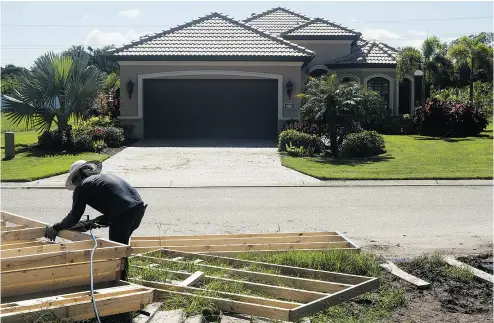  ?? TY WRIGHT / BLOOMBERG ?? A worker nails a piece of lumber to a wall frame on the site of a home under constructi­on in Ellenton, Florida. Canadians purchased 33,819 properties in the United States last year, and Florida was one of the top destinatio­ns.