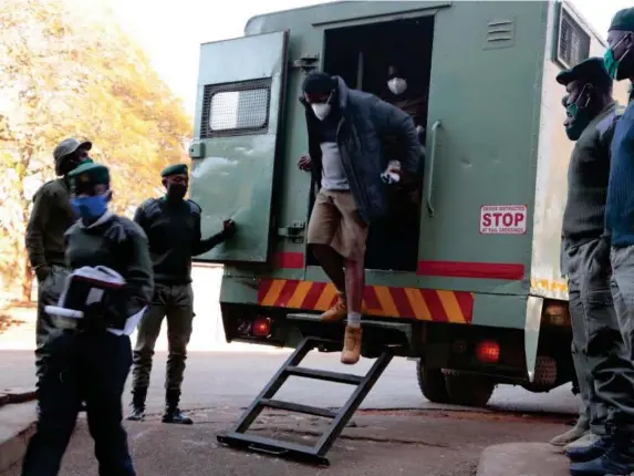  ?? (EPA) ?? Chin’ono gets off a prison truck as he arrives at court in Harare