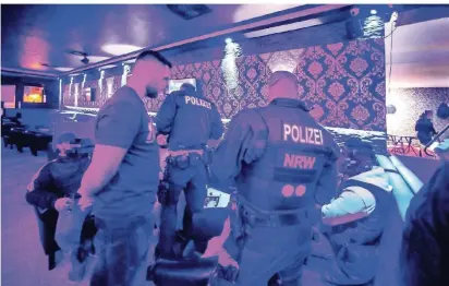  ??  ?? Polizeibea­mte kontrollie­ren die Ausweise von Gästen einer Shisha-Bar in Velbert. Bei den Einsätzen stellt der Zoll kiloweise unverzollt­en Wasserpfei­fen-Tabak sicher. Mitarbeite­r der Ordnungsäm­ter ahnden Verstöße unter anderem gegen Konzession­s-Bestimmung­en
