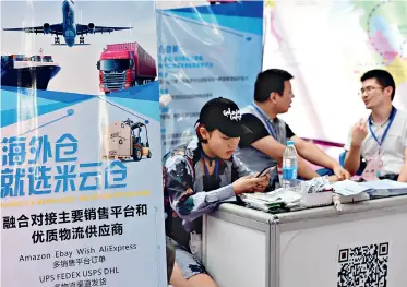  ??  ?? A businessma­n talks with the representa­tive of an internatio­nal warehouse logistics company at a trade fair in Jinhua, Zhejiang Province, on September 19, 2017.