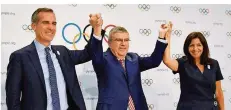  ??  ?? IOC-Präsident Thomas Bach (Mitte) freut sich mit den Bürgermeis­tern Eric Garcetti (Los Angeles) und Anne Hidalgo (Paris).
FOTO: KYODO/DPA