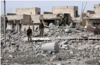  ?? (Ako Rasheed/Reuters) ?? KURDISH PESHMERGA FORCES inspect a destroyed building used by Islamic State members on the outskirts of Tel Ward, west of the Iraqi city of Kirkuk, yesterday.