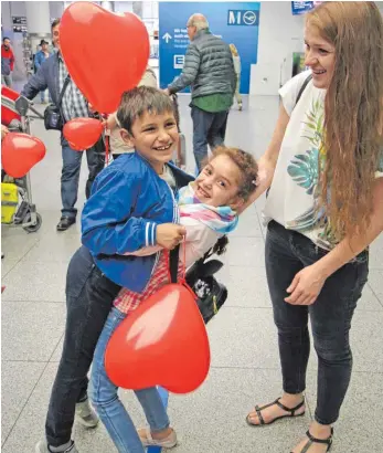  ?? FOTO: BARBARA BRAIG ?? Überschwän­gliche Freude: Lucia nimmt bei der Ankunft in München ihren Bruder Kevin in den Arm, rechts freut sich Mutter Elina Meister.