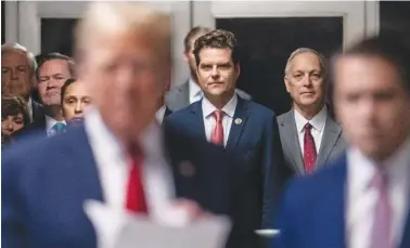  ?? JEENAH MOON/POOL PHOTO VIA AP ?? Florida Republican Rep. Matt Gaetz, center, listens Thursday as former President Donald Trump talks with the media at Manhattan criminal court in New York.