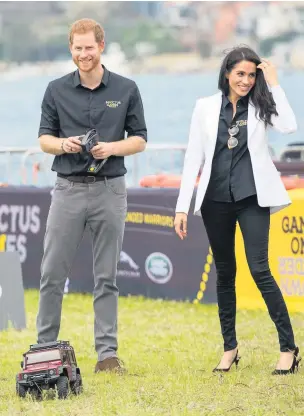  ??  ?? The Duke of Sussex drives a remote control car as the Duchess of Sussex looks on as they attend the Invictus Games Jaguar Land Rover Driving Challenge on Cockatoo Island, Sydney, on the fifth day of the royal couple’s visit to Australia yesterday