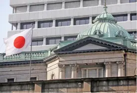  ??  ?? File photo of a Japanese flag atop the Bank of Japan headquarte­rs in Tokyo