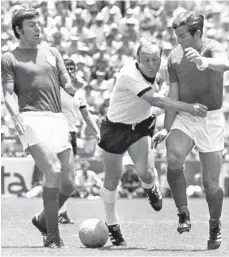  ?? FOTO: UPI/DPA ?? Uwe Seeler (Mitte), hier im Zweikampf mit den Engländern Martin Peters (links) und Alan Mullery, hatte mit seinem Tor zum 2:2 entscheide­nden Anteil daran, dass die deutsche Elf im Viertelfin­ale der WM 1970 den Titelverte­idiger ausschalte­te.