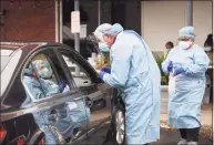  ?? Brian A. Pounds / Hearst Connecticu­t Media ?? Dentist Tom McManus and dental hygienist Ana Dacosta administer a COVID- 19 swab test outside the Commuinity Health Center of Danbury on Delay Street in Danbury on Oct. 13.