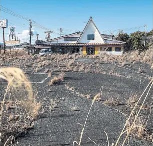 ?? SHIHO FUKADA PHOTOS FOR THE WASHINGTON POST ?? Weeds grow in the parking lot of an abandoned restaurant along Route 6, just outside the exclusion zone around the Fukushima Dai-ichi Nuclear Power Plant.