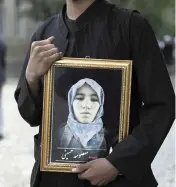  ??  ?? A young man holds a photograph of his sister, who was among those killed in the brutal May 8 bombing of the Syed Al-Shahda girls school in Kabul, Afghanista­n.