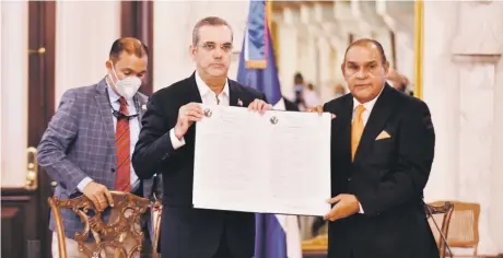  ??  ?? El presidente Luis Abinader (centro) y el director del Listín Diario, Miguel Franjul, muestran las declaracio­nes de Chapultepe­c y de Salta, firmadas por el mandatario en octubre pasado durante un acto en el Palacio Nacional.