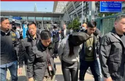  ?? ?? In this photo released by Hong Kong’s Informatio­n Services Department, Hong Kong police escort a suspect at the Shenzhen Bay Port border crossing in Hong Kong, yesterday