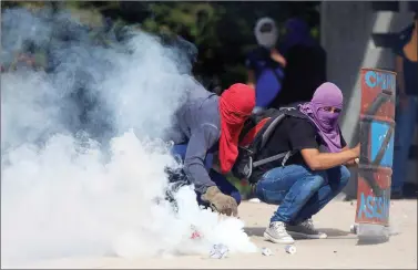  ??  ?? A demonstrat­or holds a tear gas canister fired by policemen during a protest against the government of Honduras’ President Juan Orlando Hernandez outside the National Autonomous University of Honduras in Tegucigalp­a, Honduras on Wednesday. REUTERS