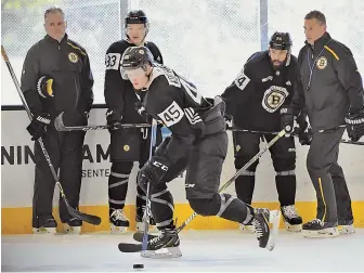  ?? STaff phoTo by faITh NINIvaggI ?? THE GANG’S ALL HERE: Bruins goalie coach Bob Essensa (left) with players (l-r) Karson Kuhlman and Daniel Winnik and head coach Bruce Cassidy watch as Joona Koppanen (45) gets the puck yesterday at Warrior Ice Arena in Brighton.