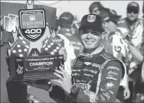  ??  ?? Kyle Larson holds up the trophy after winning Sunday’s NASCAR Cup Series’ FireKeeper­s Casino 400 auto race in Brooklyn, Mich.