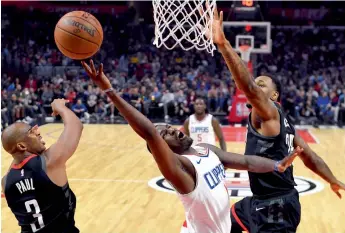  ?? AP ?? Los Angeles Clippers’ Jawun Evans ( centre) in action in their NBA game against Houston Rockets in Los Angeles on Monday. The Clippers won 113- 102. —