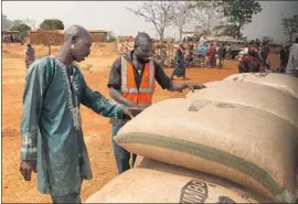  ??  ?? FARMER and teacher Samuel Augustine, 54, sells grain at a market in Kaduna state. His 18-year-old son was one of four people killed in the Kutura attack.