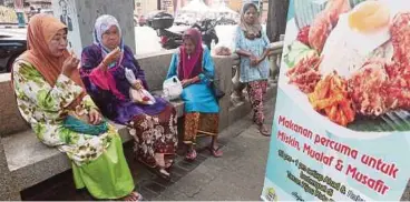  ?? [FOTO ZAMAN HURI ISA /BH] ?? Dari kiri, Wan Jah bersama Rokiah Ismail, Esah dan Rozita Arshad menikmati agihan makanan percuma di pekarangan IIDAC, Kota Bharu, semalam.