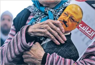  ?? EMRAH GUREL/ASSOCIATED PRESS ?? A woman holds a poster Friday during the funeral prayers for Saudi writer Jamal Khashoggi, who was killed last month in the Saudi Consulate in Istanbul. The Trump administra­tion denied Saturday that it had reached a final determinat­ion in Khashoggi’s death.