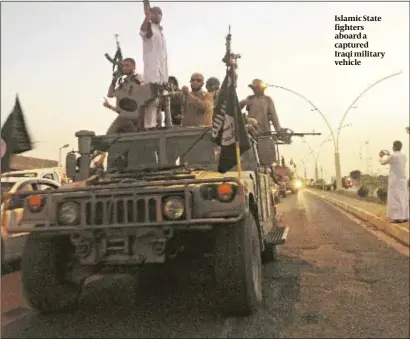  ?? PHOTO: AP ?? Islamic State fighters aboard a captured Iraqi military vehicle