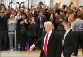  ?? THE ASSOCIATED PRESS ?? President-elect Donald Trump walks past a crowd as he leaves the New York Times building following a meeting Tuesday in New York.