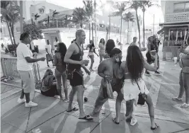  ?? MATIAS J. OCNER mocner@miamiheral­d.com ?? Tourists dance on Ocean Drive in Miami Beach on Monday.