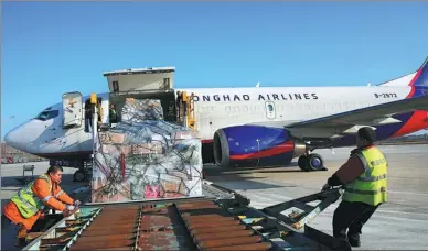  ?? XU CONGJUN / FOR CHINA DAILY ?? Ground staff load cargo at Nantong Airport, Jiangsu province.