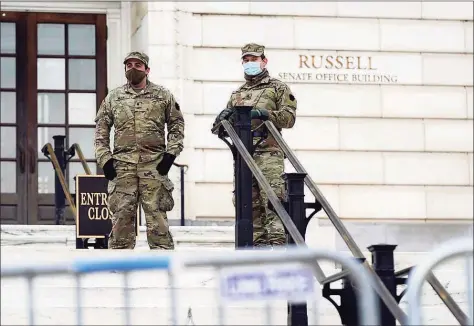 ?? Patrick Semansky / Associated Press ?? Members of the military stand guard outside Russell Senate Office Building on Capitol Hill in Washington on Friday in response to supporters of President Donald Trump who stormed the U.S. Capitol earlier in the week.