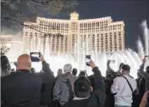  ?? Las Vegas Review-journal @Elipagepho­to ?? Elizabeth Page Brumley
Visitors watch the Fountains of Bellagio while celebratin­g New Year’s Eve on the Strip, which saw crowds despite pandemic concerns.