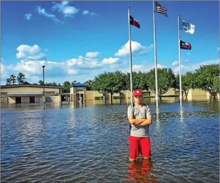  ?? SUBMITTED PHOTO ?? A student stands in knee-high water outside his school, Hardin-Jefferson Middle School in Texas, seen in the background. The middle school has been destroyed by flood water from Hurricane Harvey and Unionville High School is pledging their help in the...