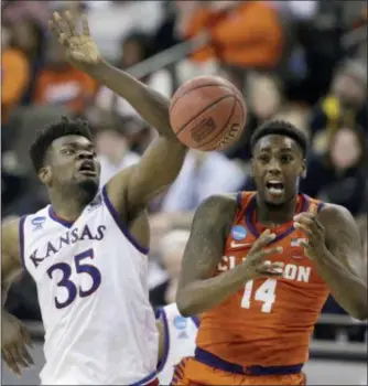  ?? CHARLIE NEIBERGALL — THE ASSOCIATED PRESS ?? Clemson’s Elijah Thomas (14) and Kansas’ Udoka Azubuike (35) reach for a rebound during the first half of a regional semifinal game in the NCAA men’s college basketball tournament Friday in Omaha, Neb.