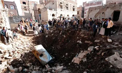  ??  ?? People look at the damage in the aftermath of an air strike in the Yemeni capital of Sanaa on 11 November. Photograph: AFP/ Getty Images