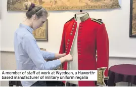  ??  ?? A member of staff at work at Wyedean, a Haworthbas­ed manufactur­er of military uniform regalia