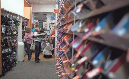  ??  ?? Shoppers roam the aisles of a Payless ShoeSource in Mesa, Ariz., in 2014. Payless emerged from bankruptcy in August after closing about 900 stores and shedding debt that investors had piled onto the company. USA TODAY NETWORK FILE PHOTO