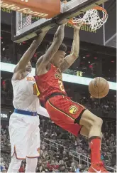  ?? AP PHOTO ?? ROCKING THE RIM: John Collins throws down a dunk in front of the Knicks’ Frank Ntilikina during the Hawks’ victory last night in Atlanta.