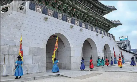  ??  ?? Twice daily, tourists watch the changing of the guard at the Guanghwamu­n Gate of Gyeongbokg­ung Palace in Seoul. It’s a colorful, elaborate affair, but entirely ceremonial.