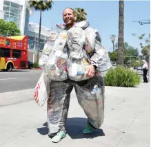  ?? — AFP photo ?? Greenfield walks around Beverly Hills wearing a suit filled with every piece of trash he has generated living and consuming like a typical American for one month to raise awareness about how much garbage just one person generates.
