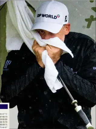 ??  ?? AT THE MERCY OF THE WEATHER: Poulter tries to dry off during yesterday’s downpours but he is not complainin­g as he remains firmly in contention to win