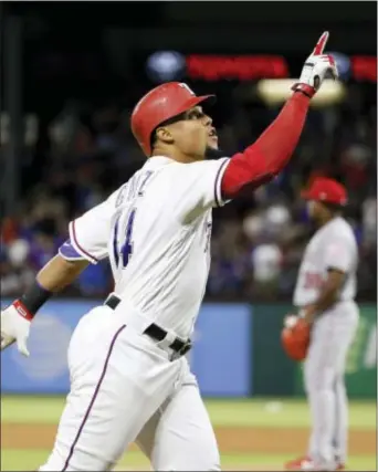  ?? TONY GUTIERREZ — THE ASSOCIATED PRESS ?? Texas’ Carlos Gomez points skyward as he approaches the plate after hitting a two-run home run off Angels relief pitcher Jose Valdez, rear, during the seventh inning in Arlington, Texas, Saturday. Gomez hit for the cycle.