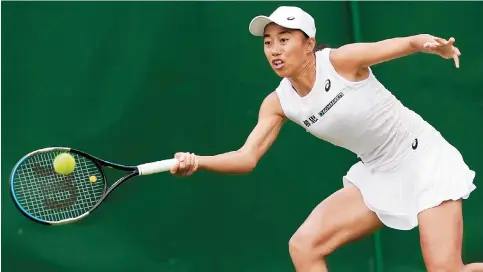  ?? Photo: Reuters ?? China’s Zhang Shuai returns during her first-round match against Japan’s Misaki Doi at Wimbledon yesterday. Zhang won the encounter in straight sets 6-4, 6-0.