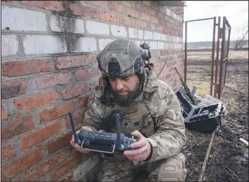  ?? EVGENIY MALOLETKA / ASSOCIATED PRESS ?? A Ukrainian serviceman who goes by the name Zakhar looks at a screen of a drone remote control during fighting March 3 near Bakhmut, Ukraine.