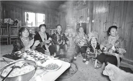  ??  ?? Miao ethnic group villagers in traditiona­l clothes watch a grand gala on TV to mark the 60th anniversar­y of the founding of the Guangxi Zhuang Autonomous Region. — IC