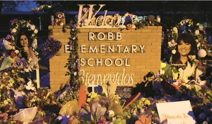  ?? ALEX WONG/GETTY ?? Flowers and photograph­s sit June 3 at a memorial dedicated to the victims of the mass shooting at Robb Elementary School in Uvalde, Texas.